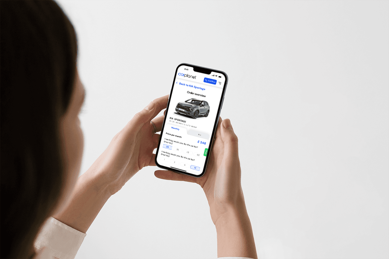 Person holding a phone with a car finance app